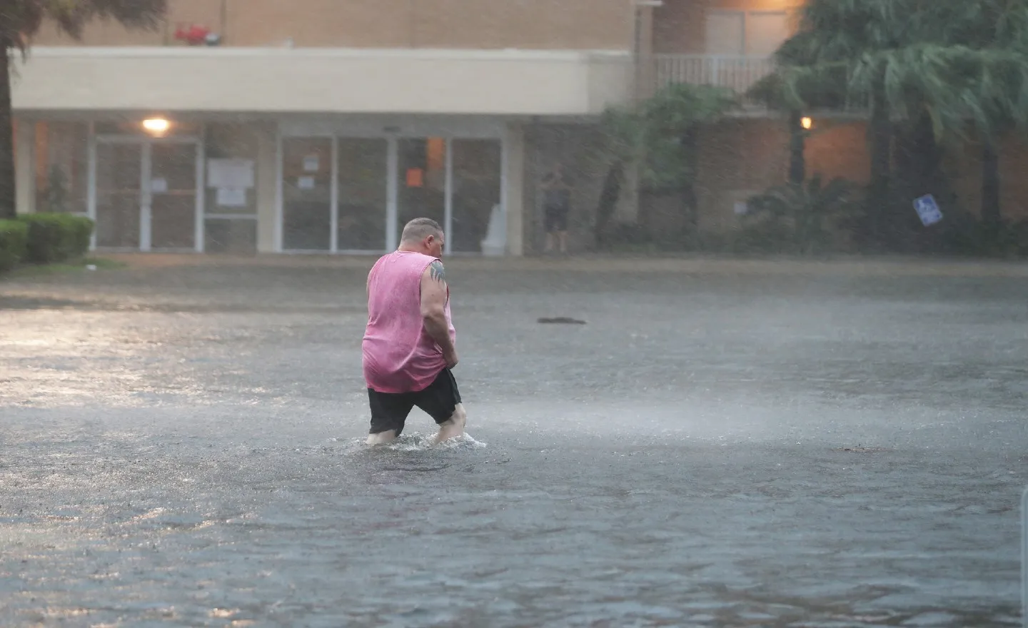 getty:A man walks though a flooded parking lot as the outer bands of Hurricane Sally come ashore on September 15, 2020 in Gulf Shores, Alabama