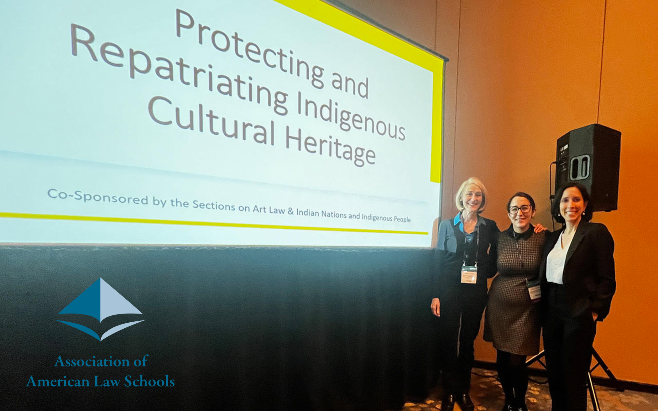 Professor Bronin stands with two others in front of a screen which reads "Protecting and Repatriating Indigenous Cultural Heritage."