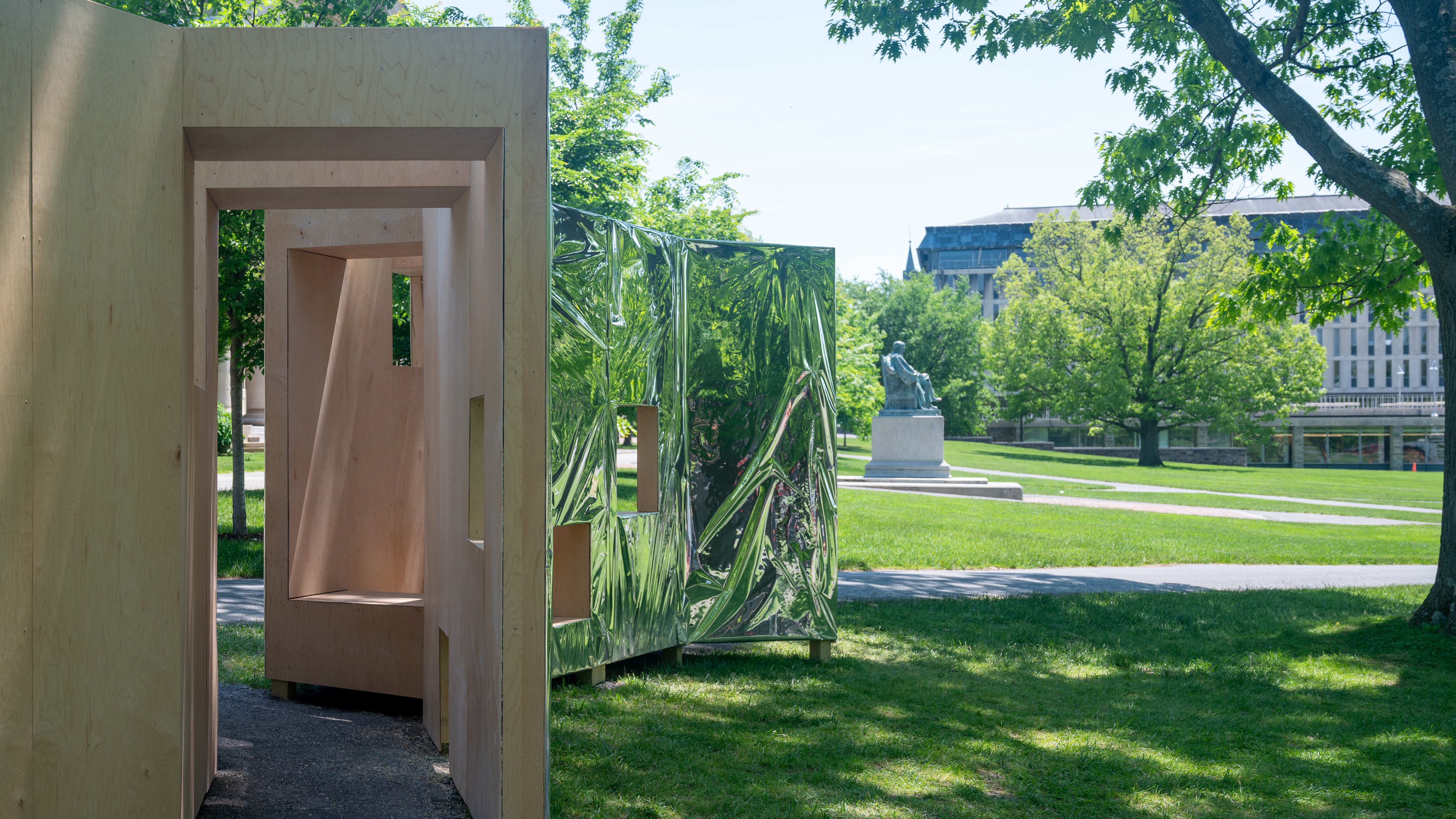 Timber pavillion with reflective exterior in park
