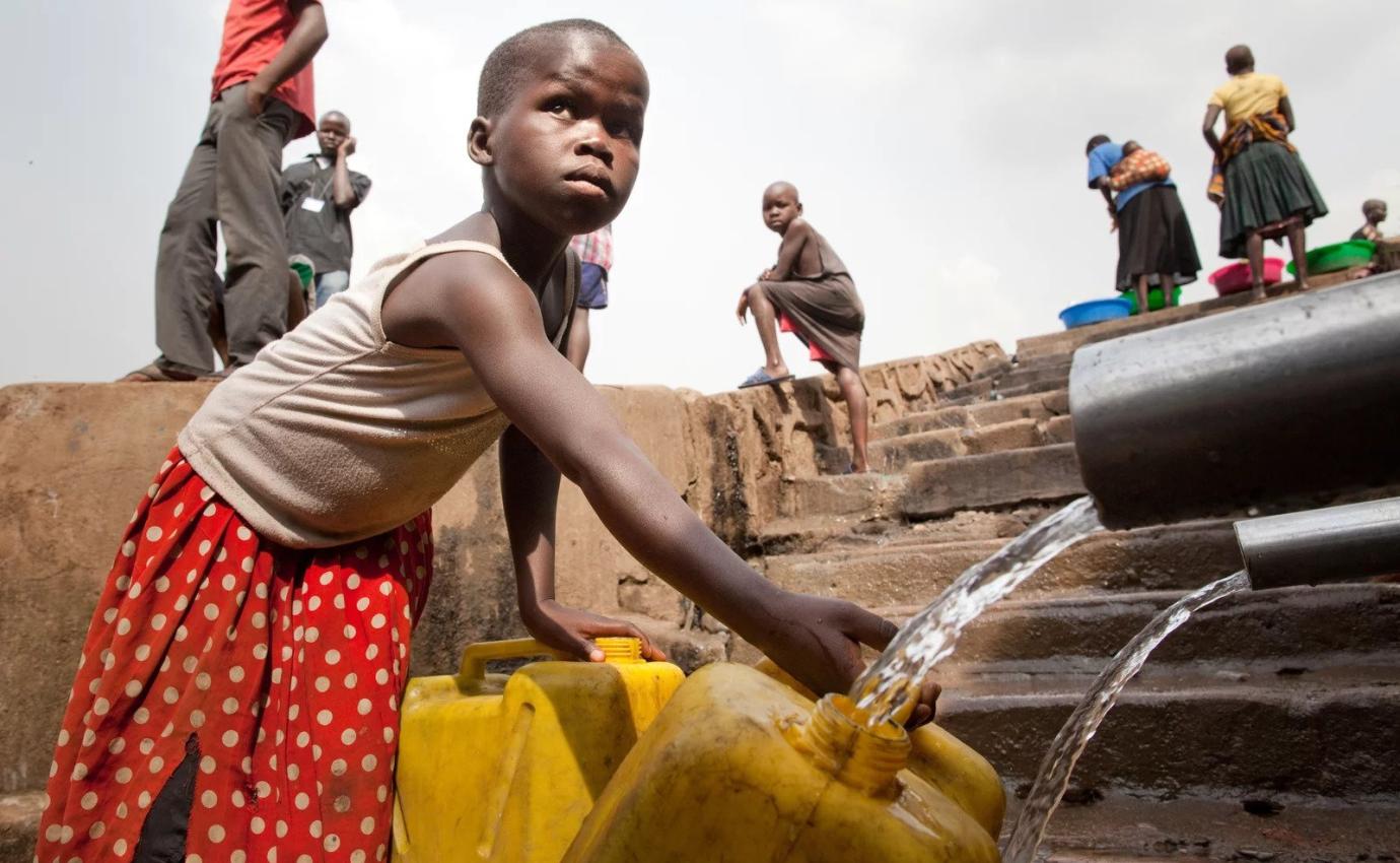 A child in a neighborhood in Kampala, Uganda, fills a container with water