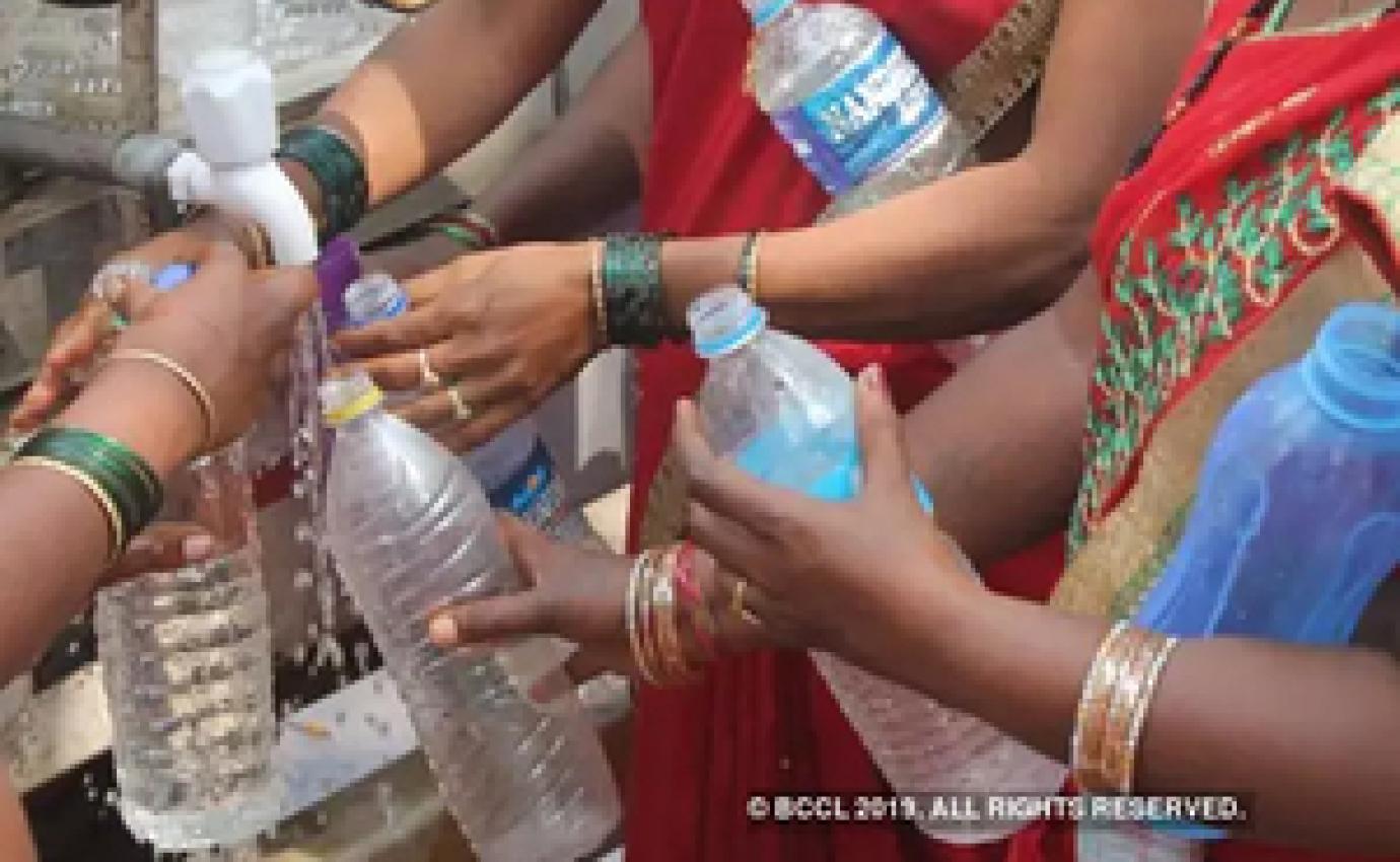 Indian women filling plastic water bottles at a tap